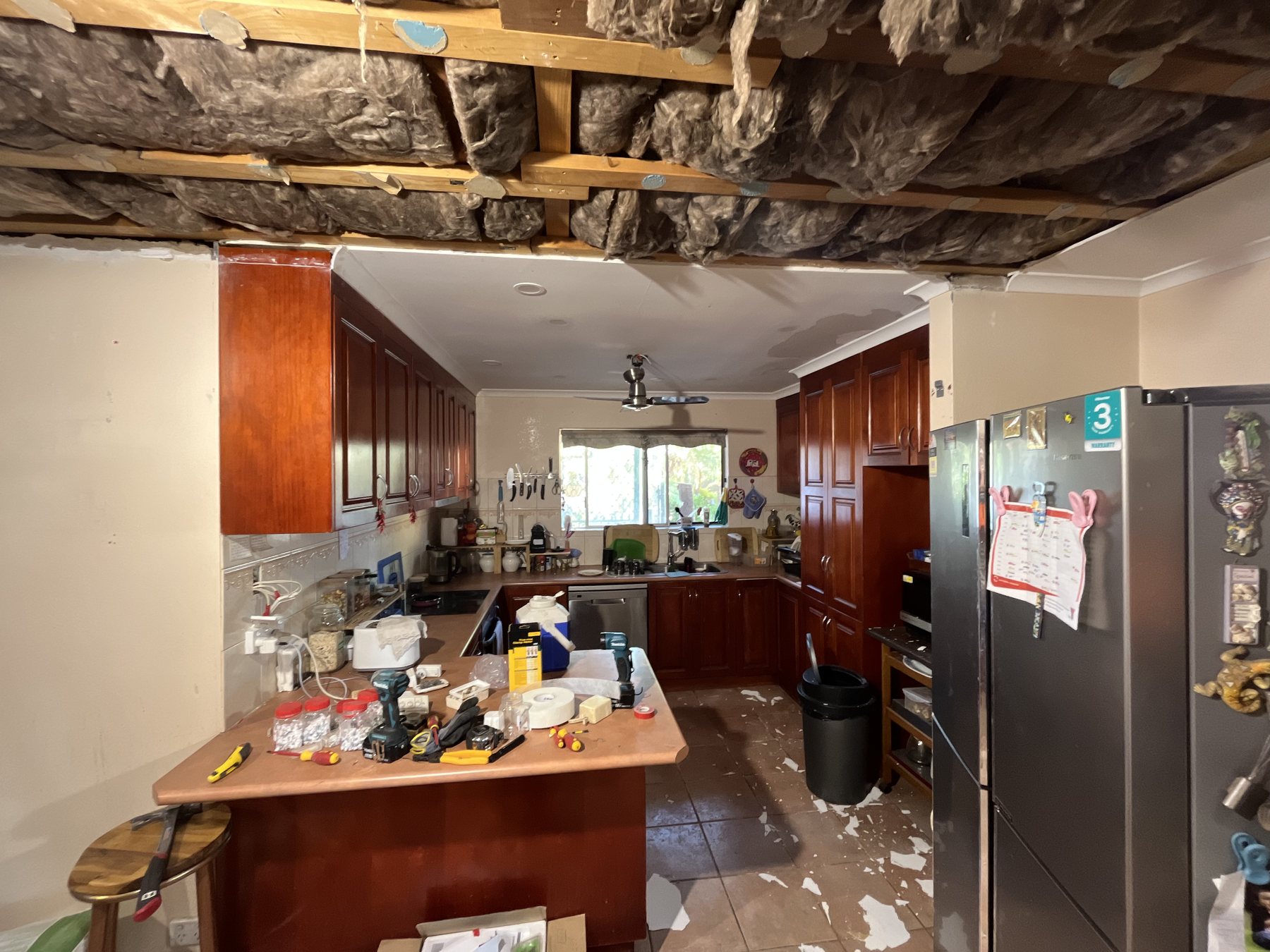 Ceiling down — roof frame and old insulation exposed.